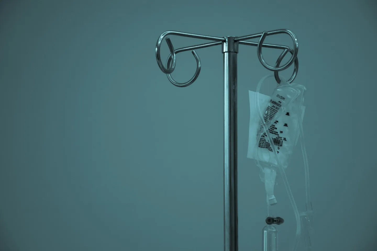 Bolsa de suero intravenoso (IV) colgada de un soporte metálico.