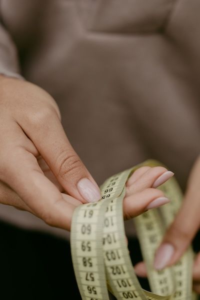 Hands holding a measuring tape.