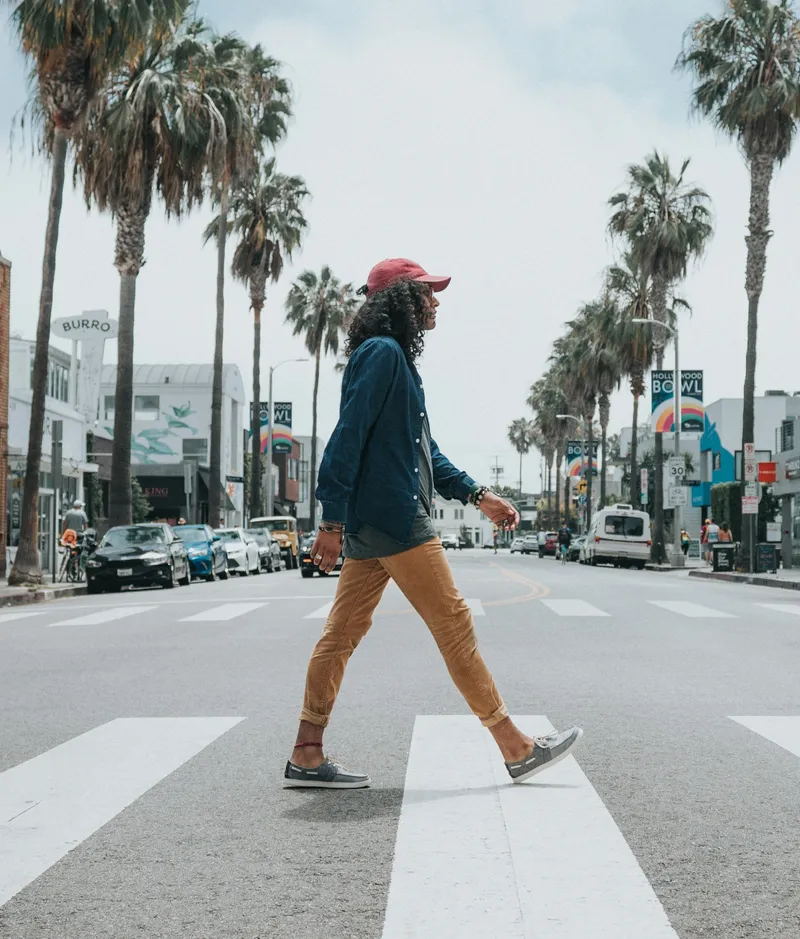 Persona con una gorra roja cruzando la calle.