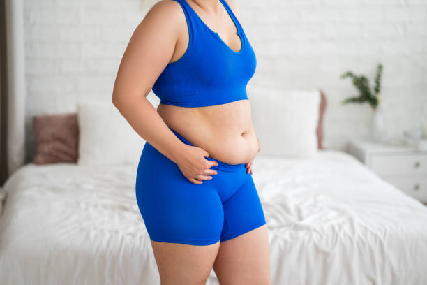 Woman with belly fat in blue workout clothes